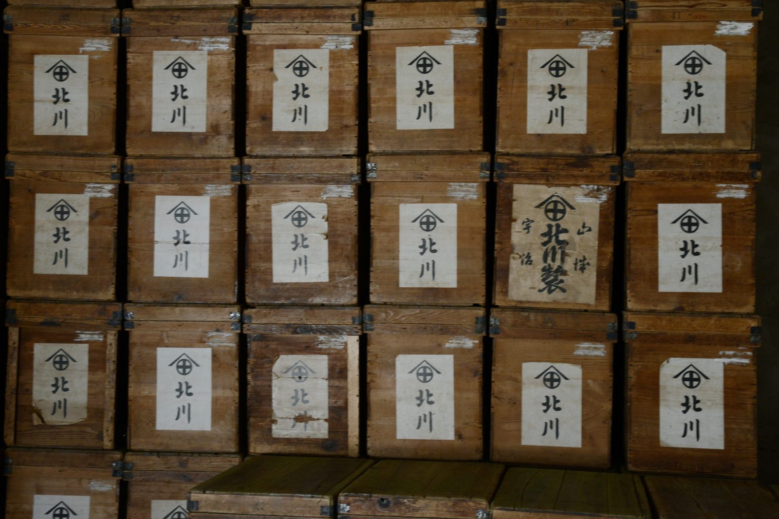 Wall of traditional wooden tea storage crates with Japanese calligraphy labels